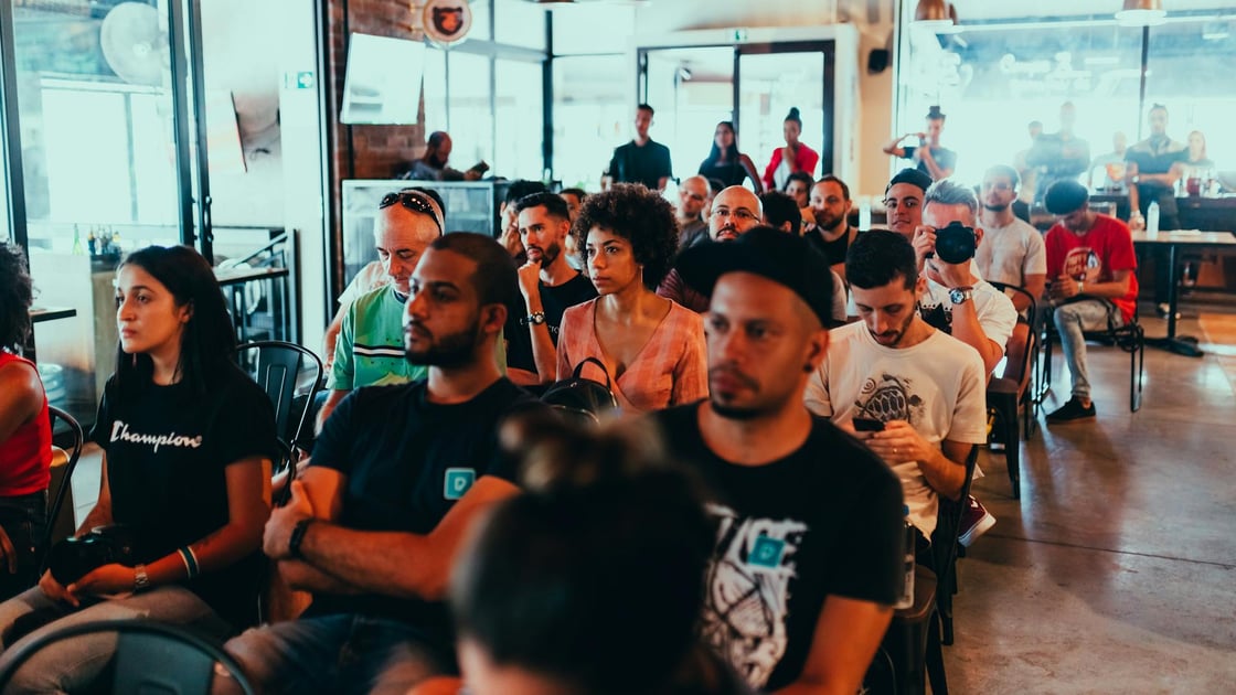 Attendees of a tech conference sitting in chairs in a room
