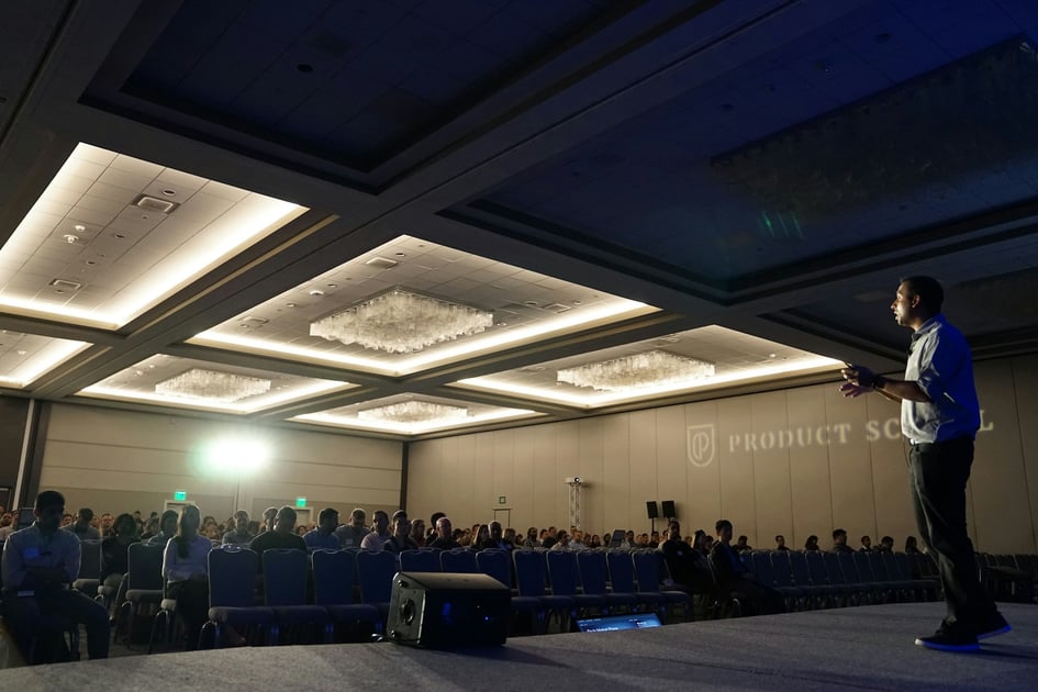 A man on stage giving a talk at a tech conference